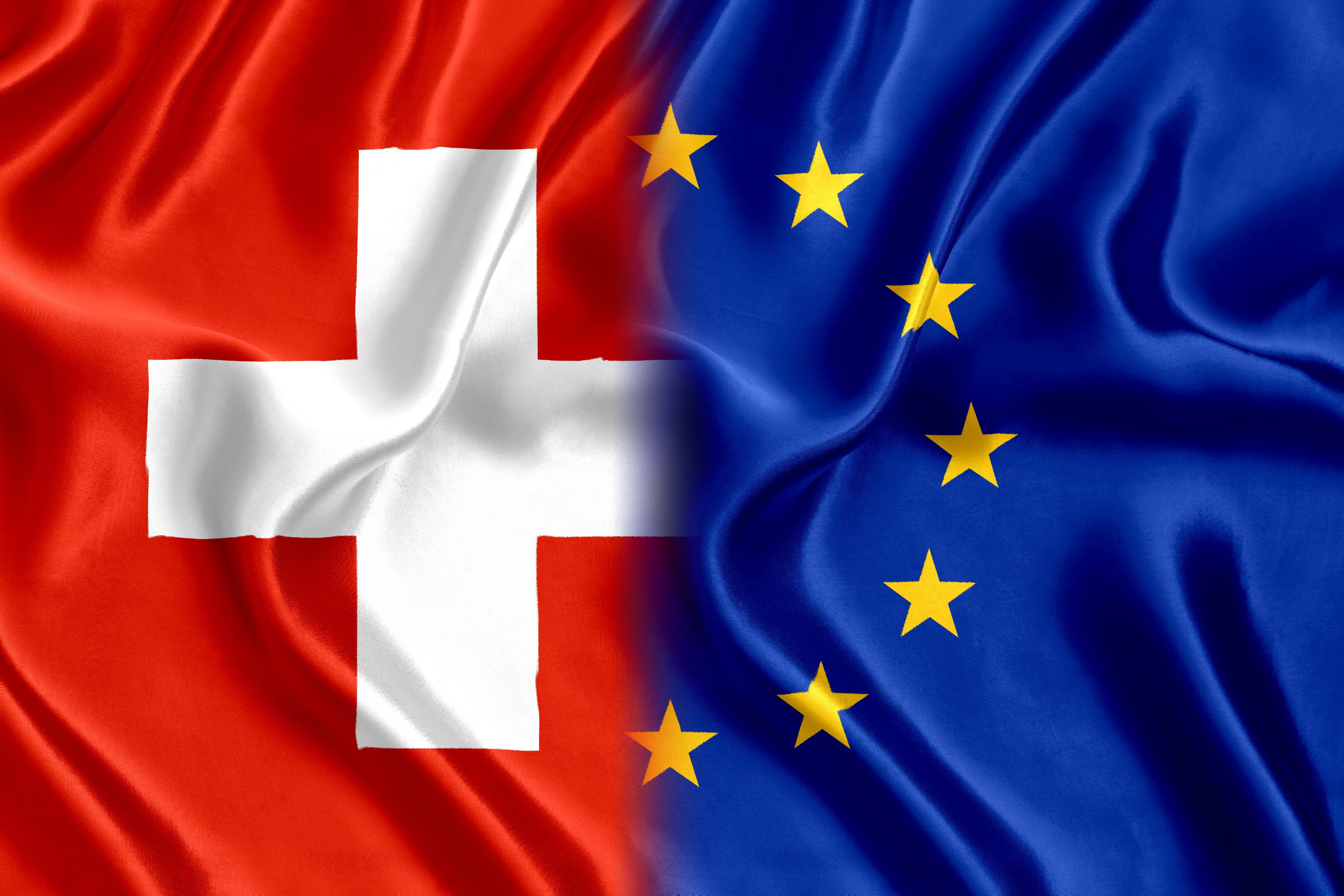 Schweiz- und EU-Flagge nebeneinander; Privatdetektei aus der Schweiz, Detektivbüro aus der Schweiz, Privatermittler aus der Schweiz, Wirtschaftsdetektei aus der Schweiz